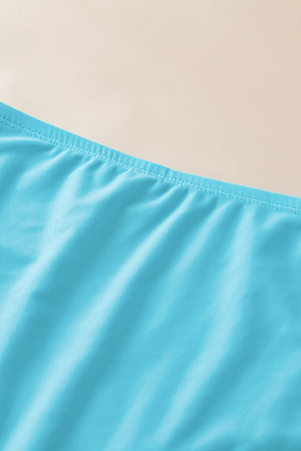 Close-up of a blue fabric with a beige background