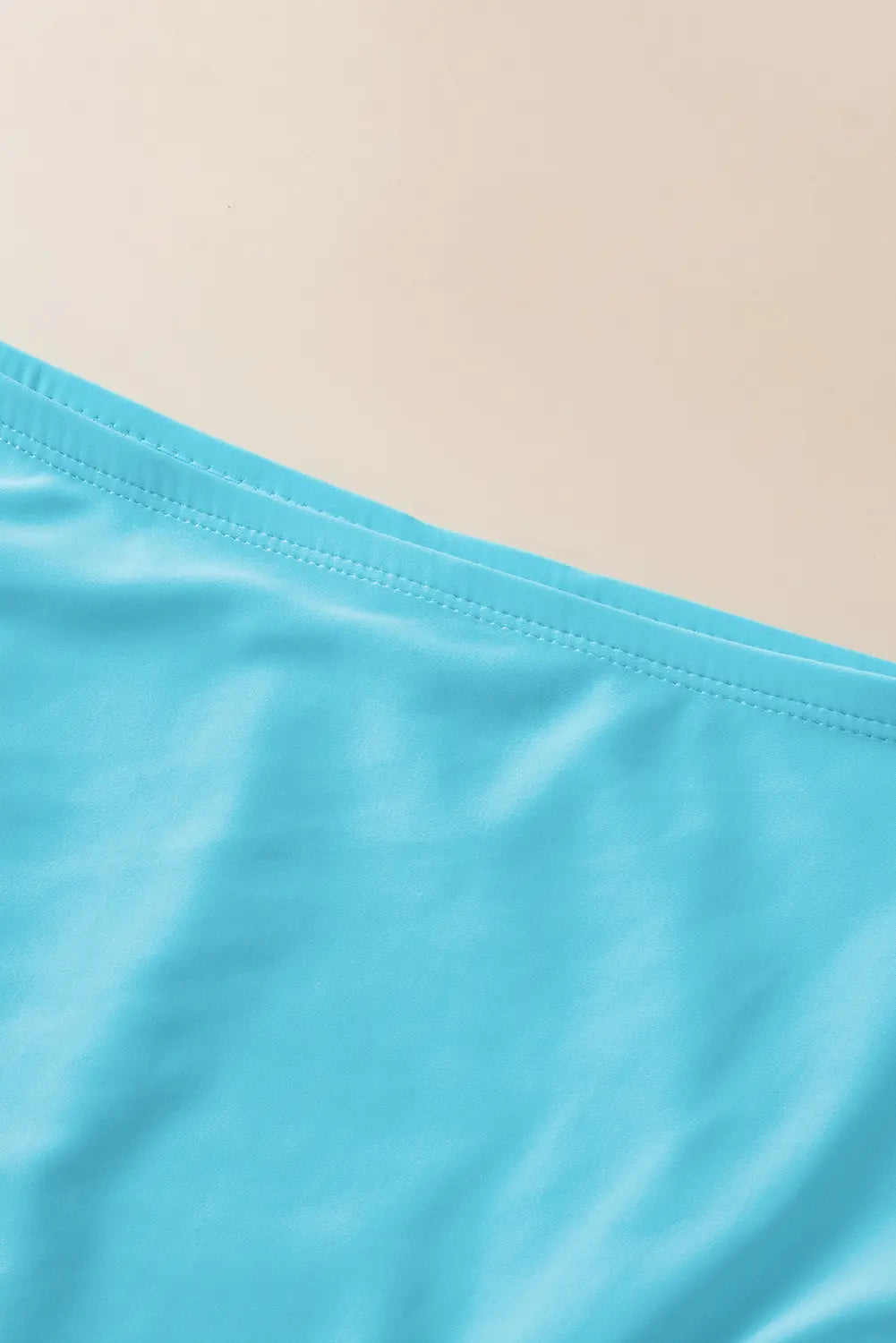 Close-up of a blue fabric with a beige background