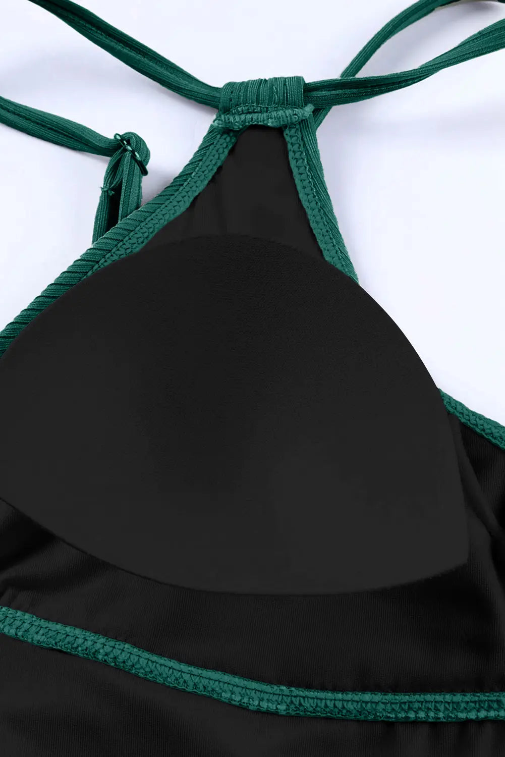 Close-up of a black bikini top or halter-style swim top with dark green braided trim and straps, shown on a plain white background.