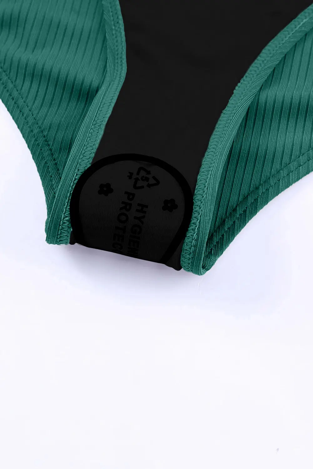 Close-up of green fabric with a brand label on a white background