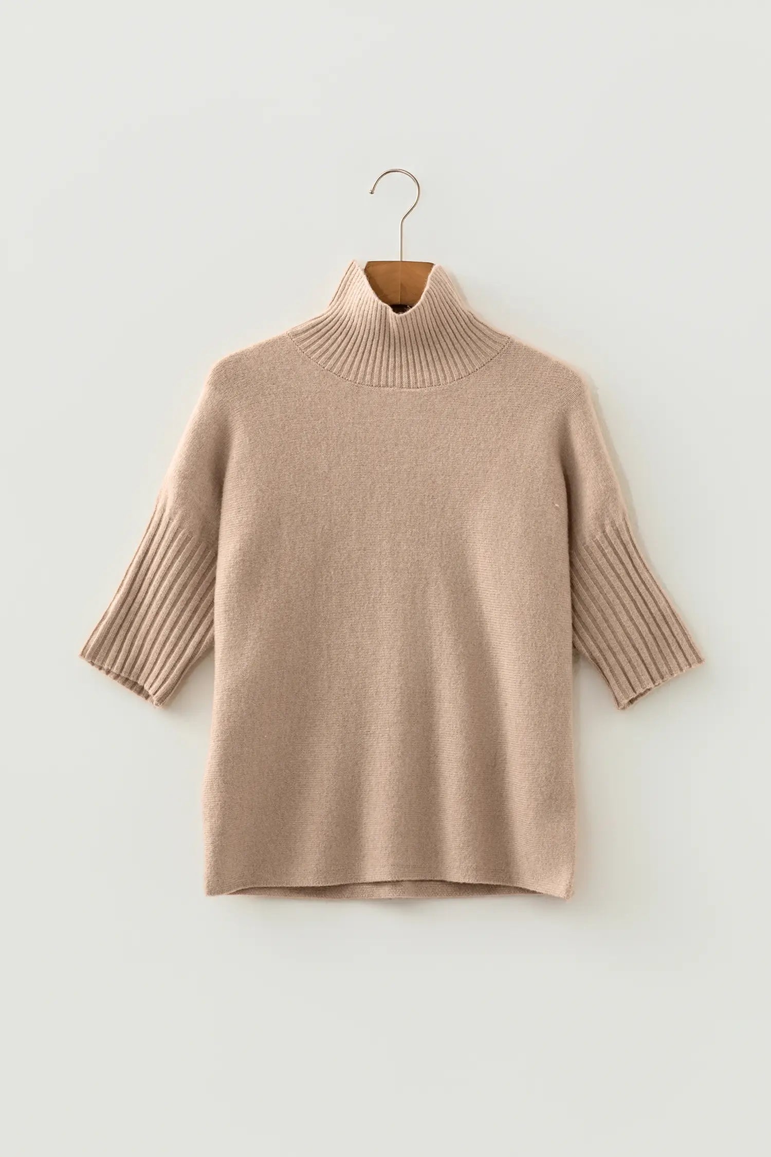 A light beige ribbed knit turtleneck sweater with elbow-length ribbed sleeves