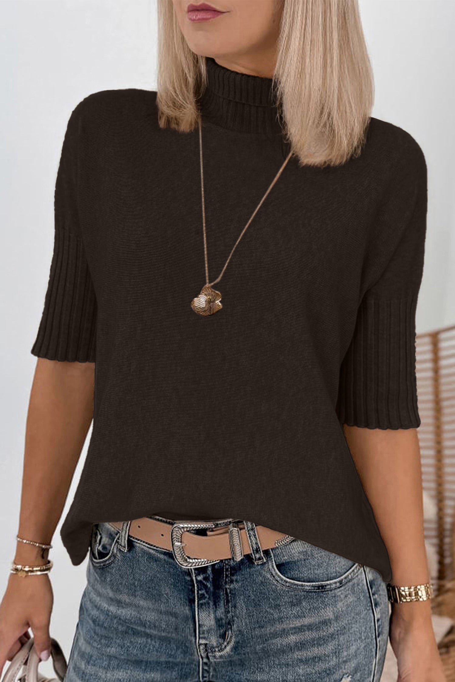 Close-up of cream textured cardigan with ribbed knit placket & gray snap on sherpa background.