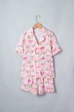 Pink pajama set with cartoon owls and bows on wooden hanger.