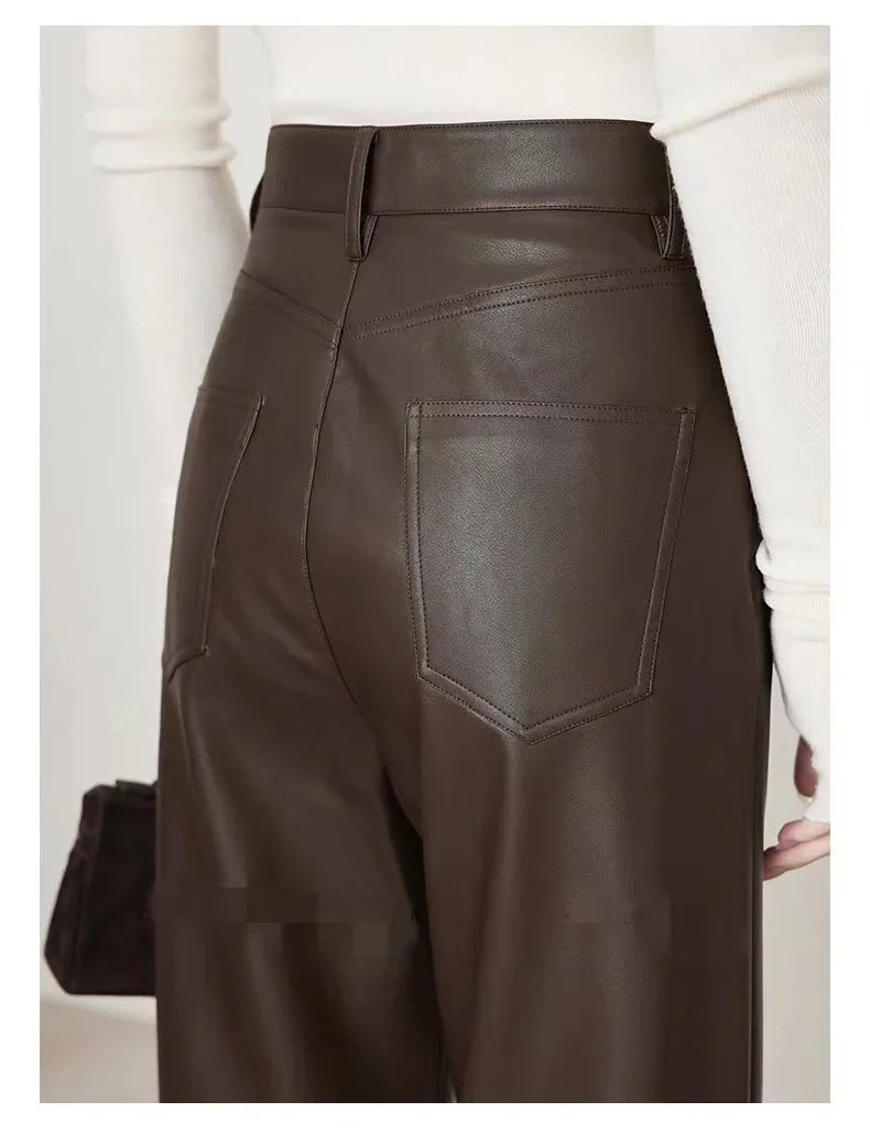 Brown leather pants worn by a person on a plain background