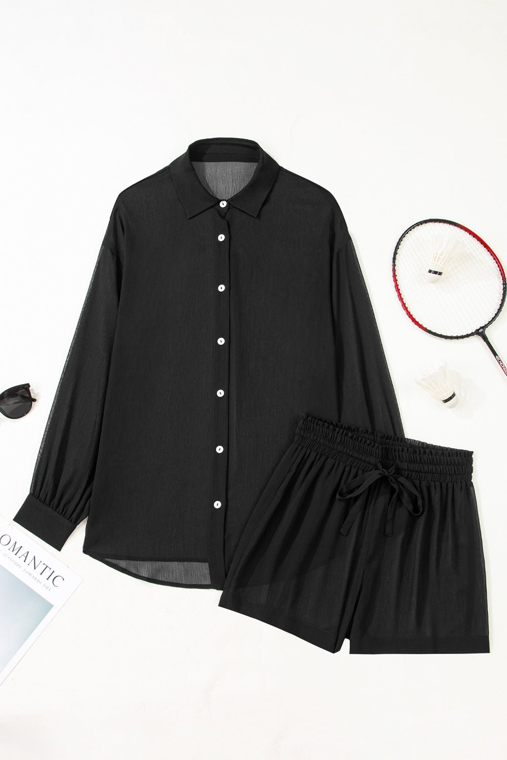 Black shirt and shorts set with a badminton racket and shuttlecock on a white background