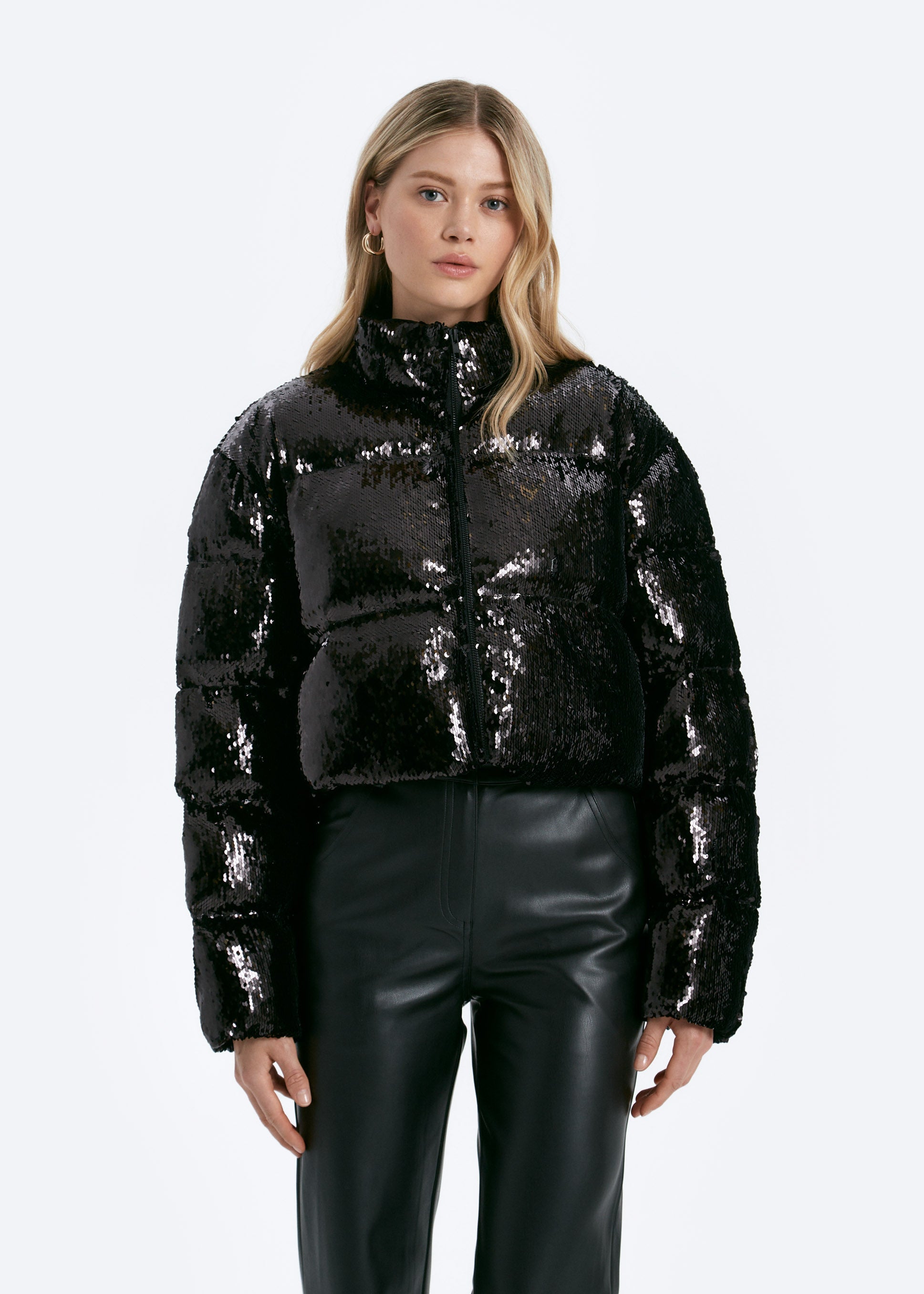 Woman wearing a black sequin jacket on a white background