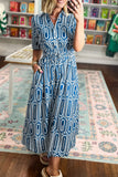 A woman wearing a blue and white geometric pattern midi dress with short sleeves, a collared neckline, and a smocked waist, standing in a retail store on a patterned rug.