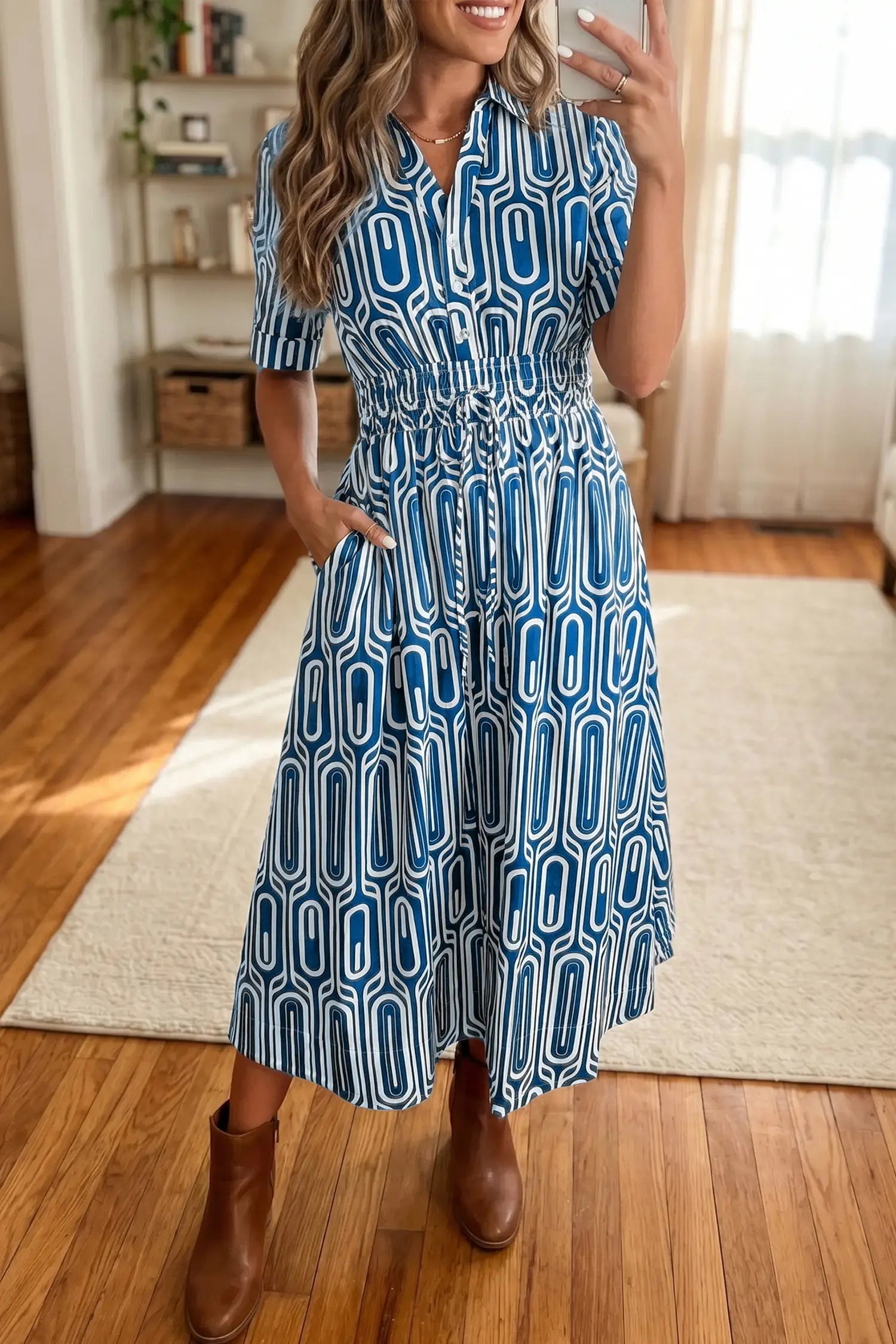 Woman wearing a blue patterned dress standing in a room with wooden flooring and a rug.
