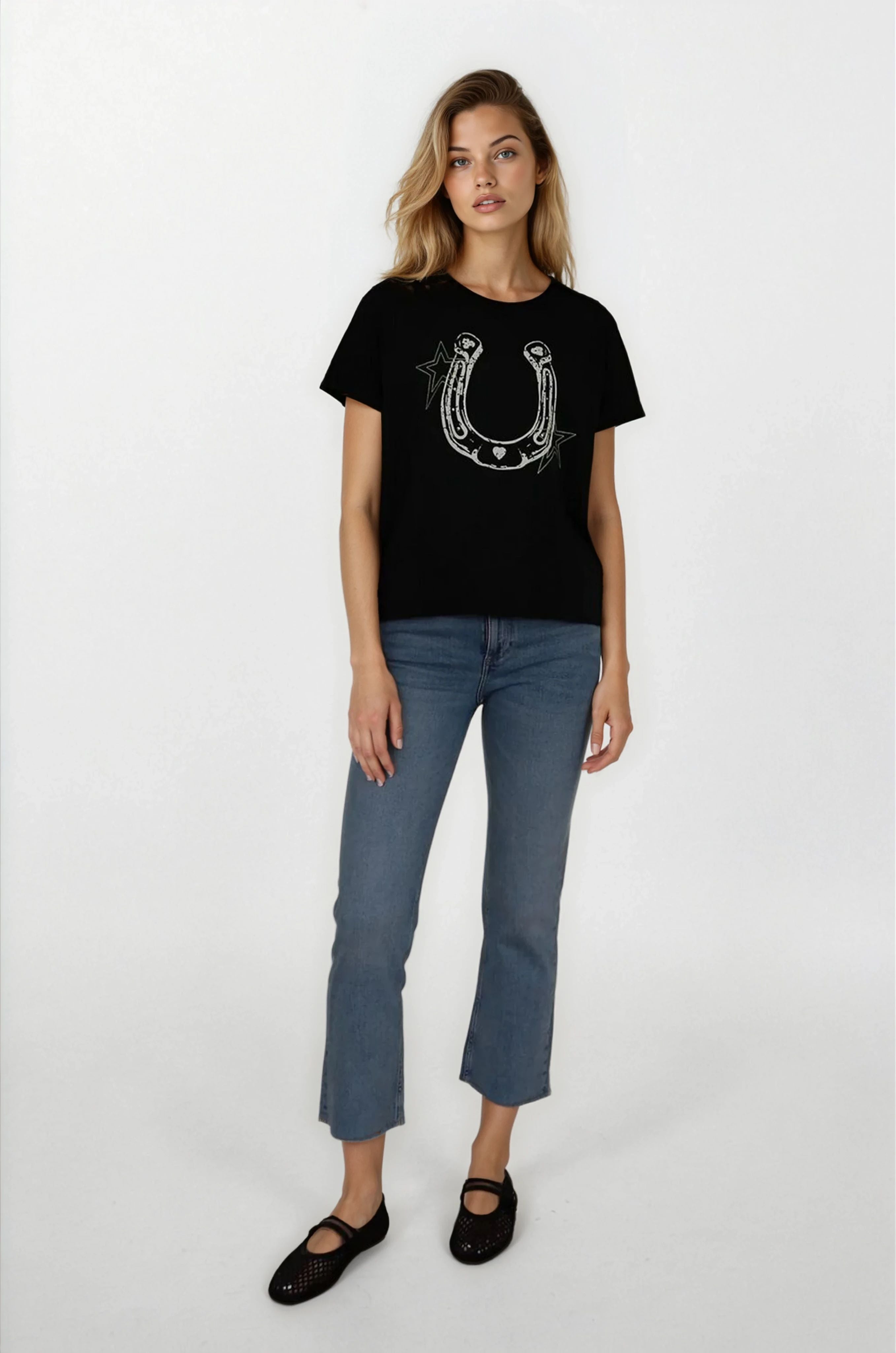 Woman wearing a black t-shirt with a horseshoe design and blue jeans on a white background
