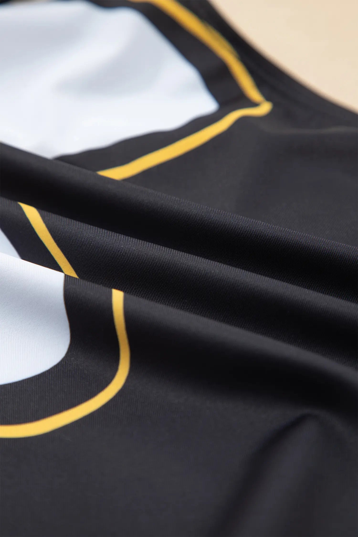 Close-up of a black sports jersey with white and yellow accents