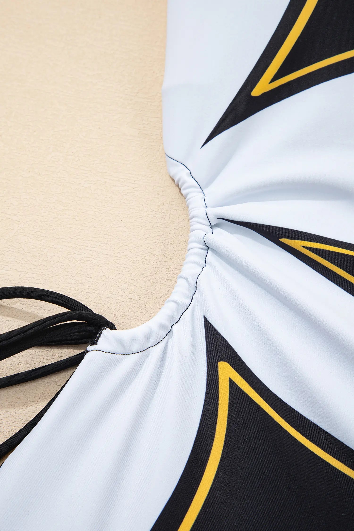 Close-up of a swimsuit with geometric patterns on a beige background