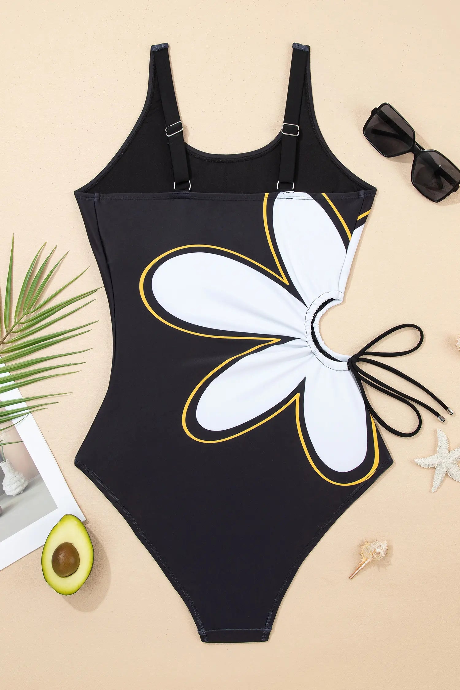 Black swimsuit with butterfly design on a beige surface