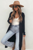 Woman in long black cardigan, beige wide-brim hat, white tank, jeans, and sunglass