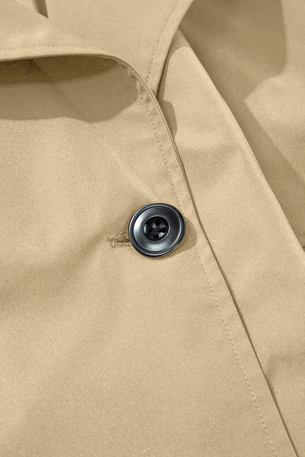 Close-up of a button on a beige fabric surface