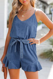 Woman wearing a blue denim romper with a blurred background