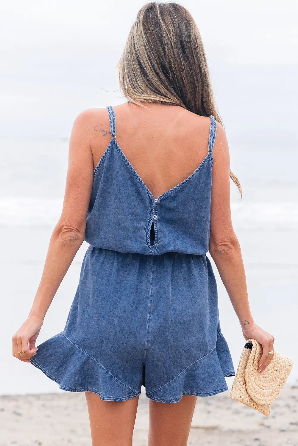 Woman wearing a denim romper with a white background