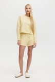 Woman wearing a yellow outfit on a white background
