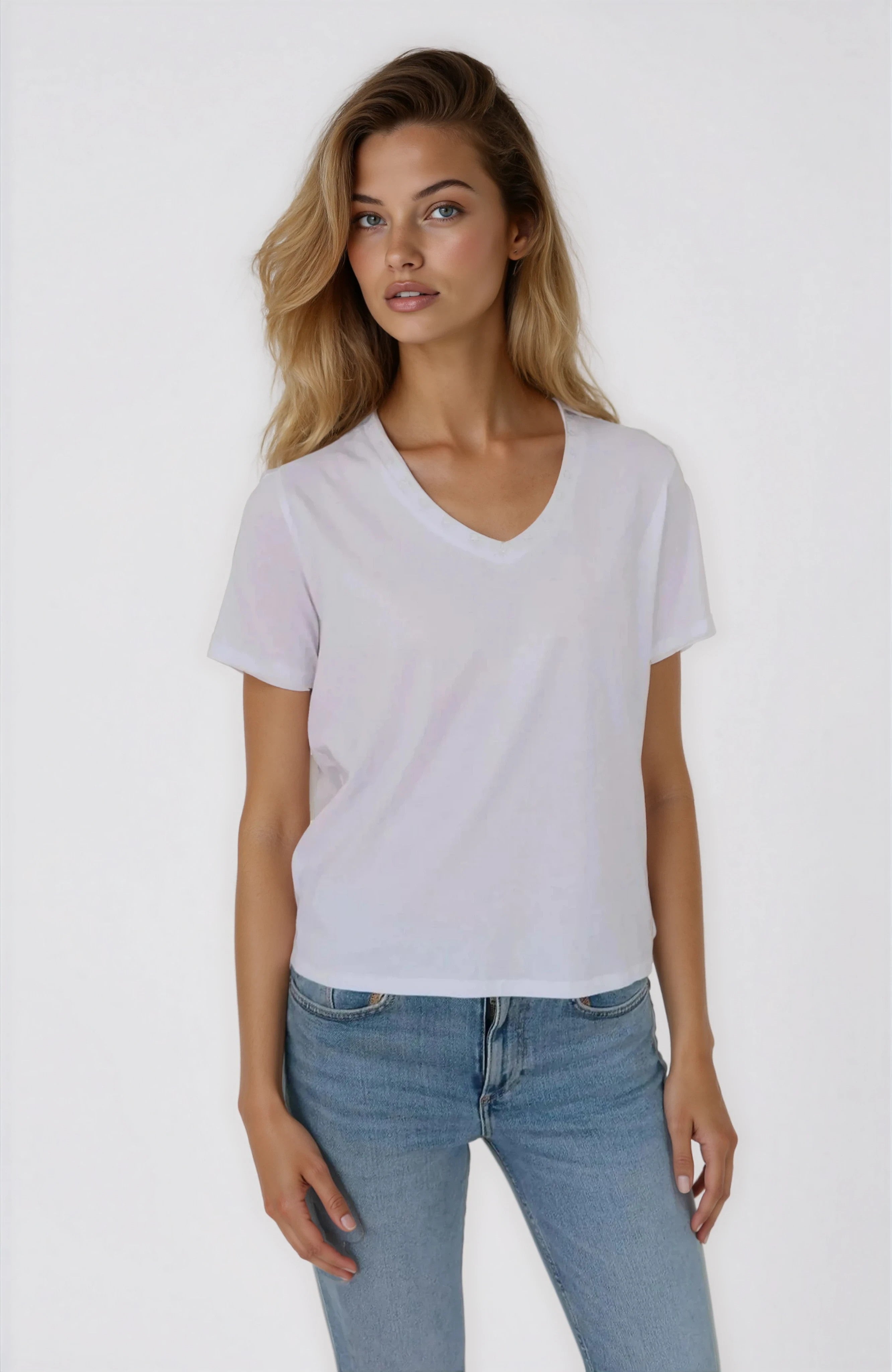 Woman wearing a plain white t-shirt and light blue jeans on a white background