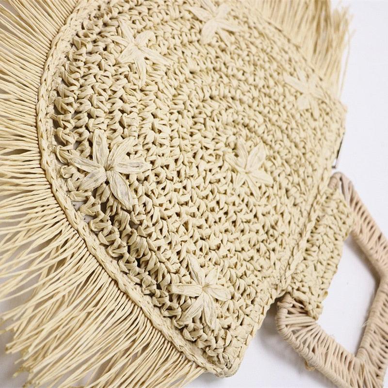 Beige woven bag with fringe details on a white background
