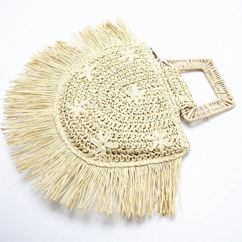 Beige woven handbag with tassels on a white background