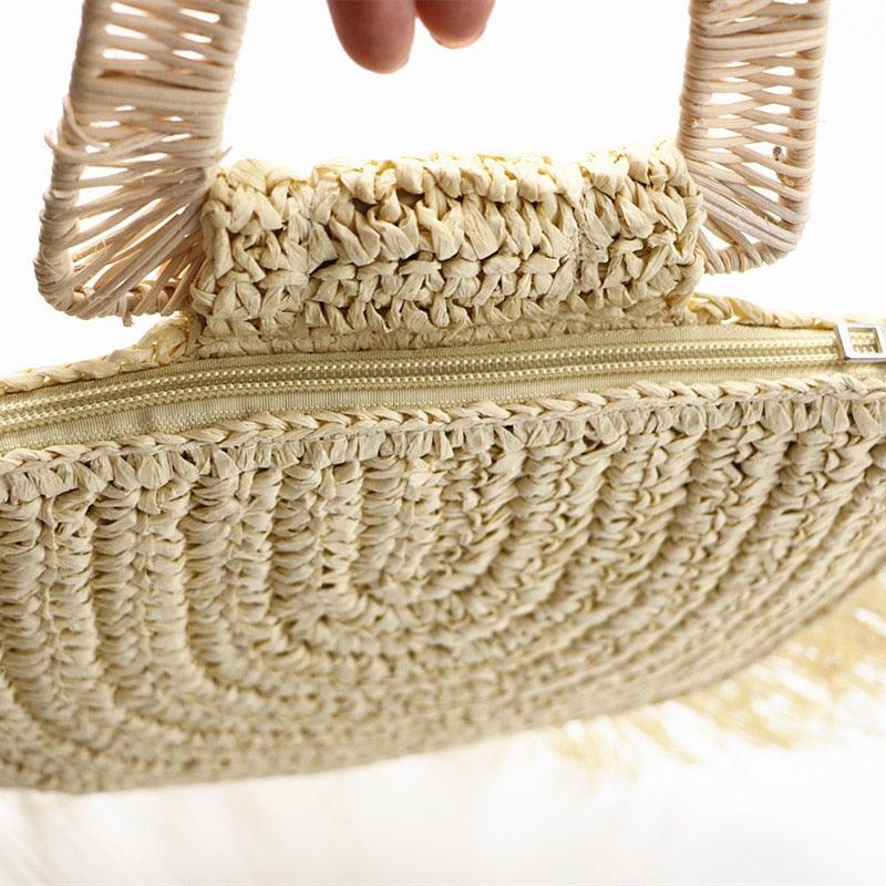 Close-up of a beige woven handbag with a zipper.