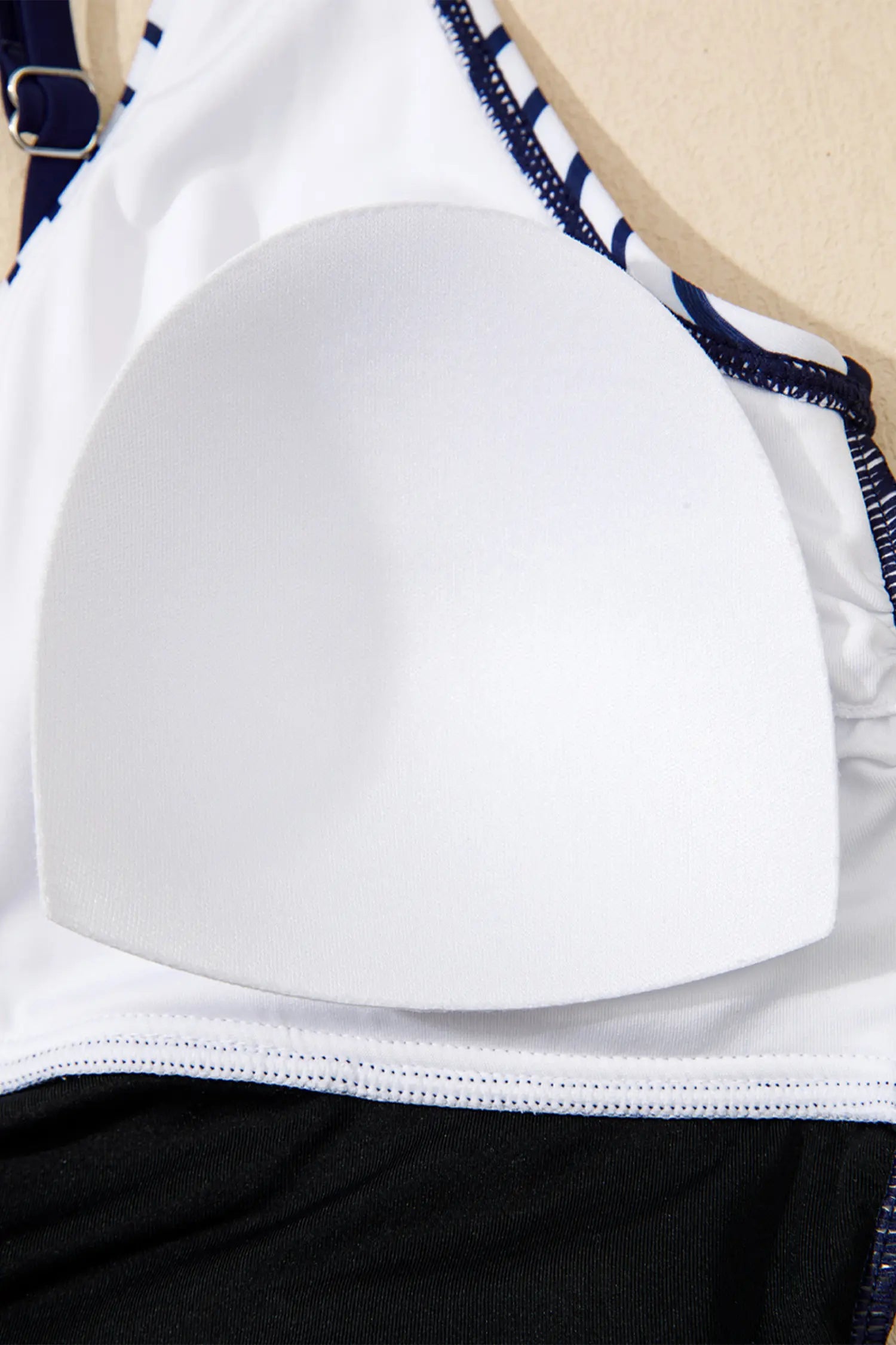 Close-up of a white bra with blue accents on a mannequin.
