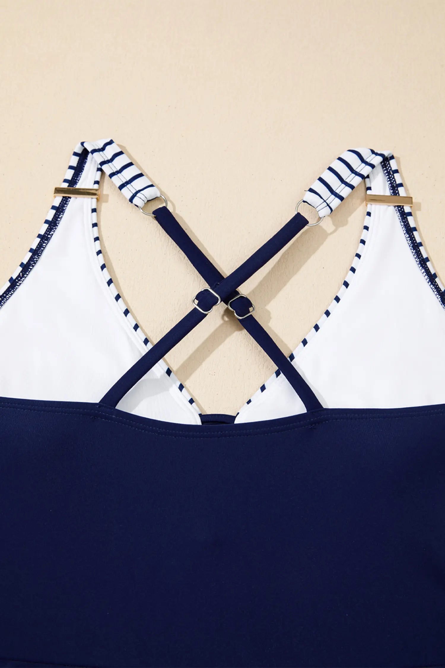 Navy and white striped top with criss-cross straps on a beige background