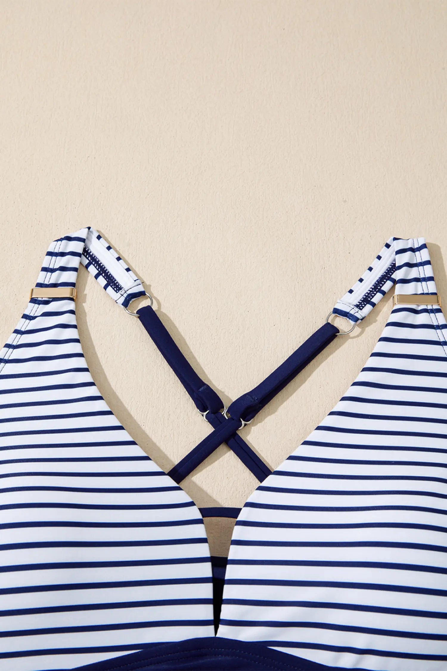 Blue and white striped bikini set on a beige background
