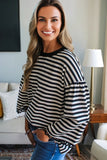Woman wearing a black and white striped sweater in a living room setting