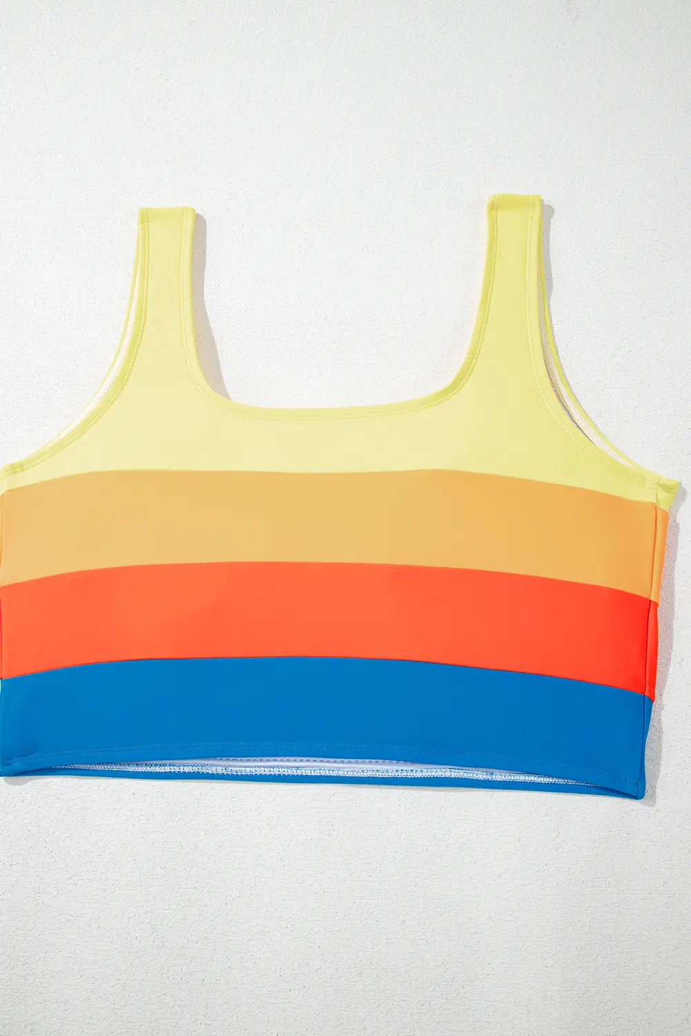 Colorful striped tank top with yellow, orange, red, and blue sections on a white background