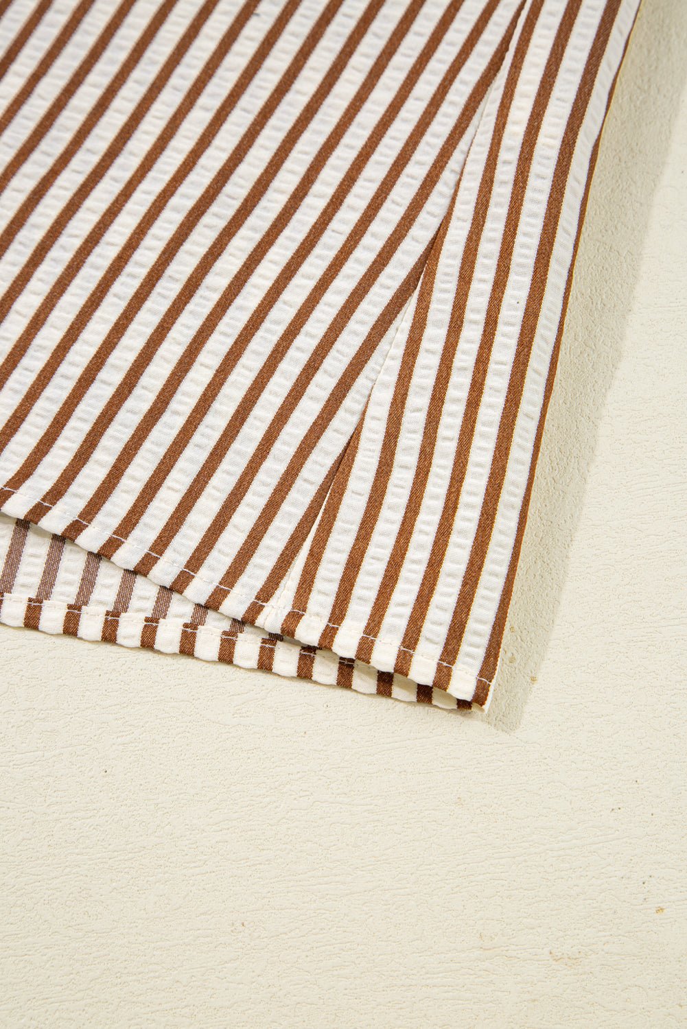 Close-up of brown and white striped fabric on a beige background