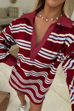 A woman wearing a long-sleeve collared shirt dress with wavy horizontal stripes in burgundy, white, and light blue, photographed in a casual indoor setting.