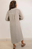 Woman wearing a long black and white striped dress against a plain background