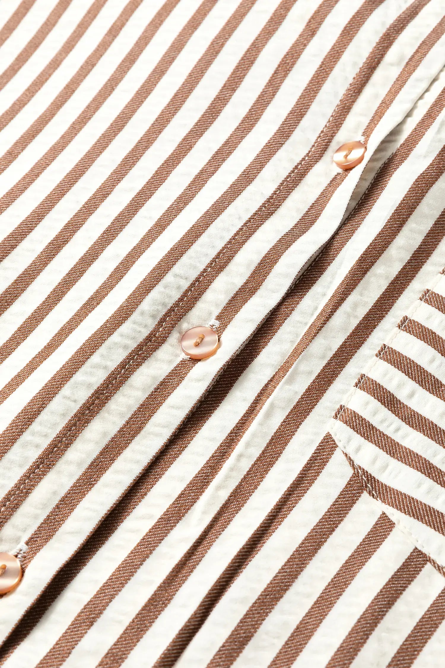 Close-up of a brown and white striped fabric with buttons.