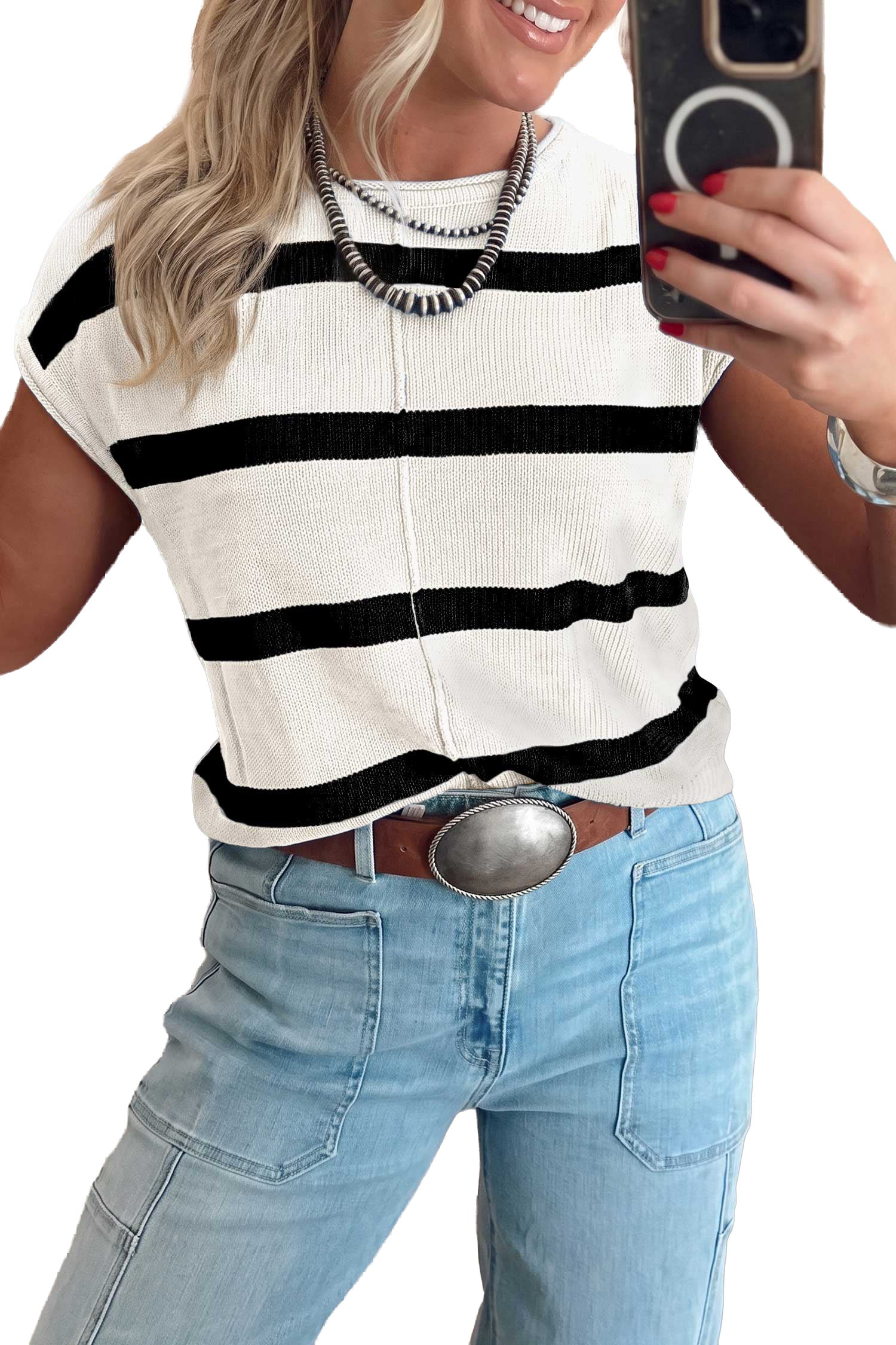 A woman takes a mirror selfie wearing a short-sleeve ribbed knit top with horizontal black stripes on an off-white base, paired with light blue jeans and a silver belt.