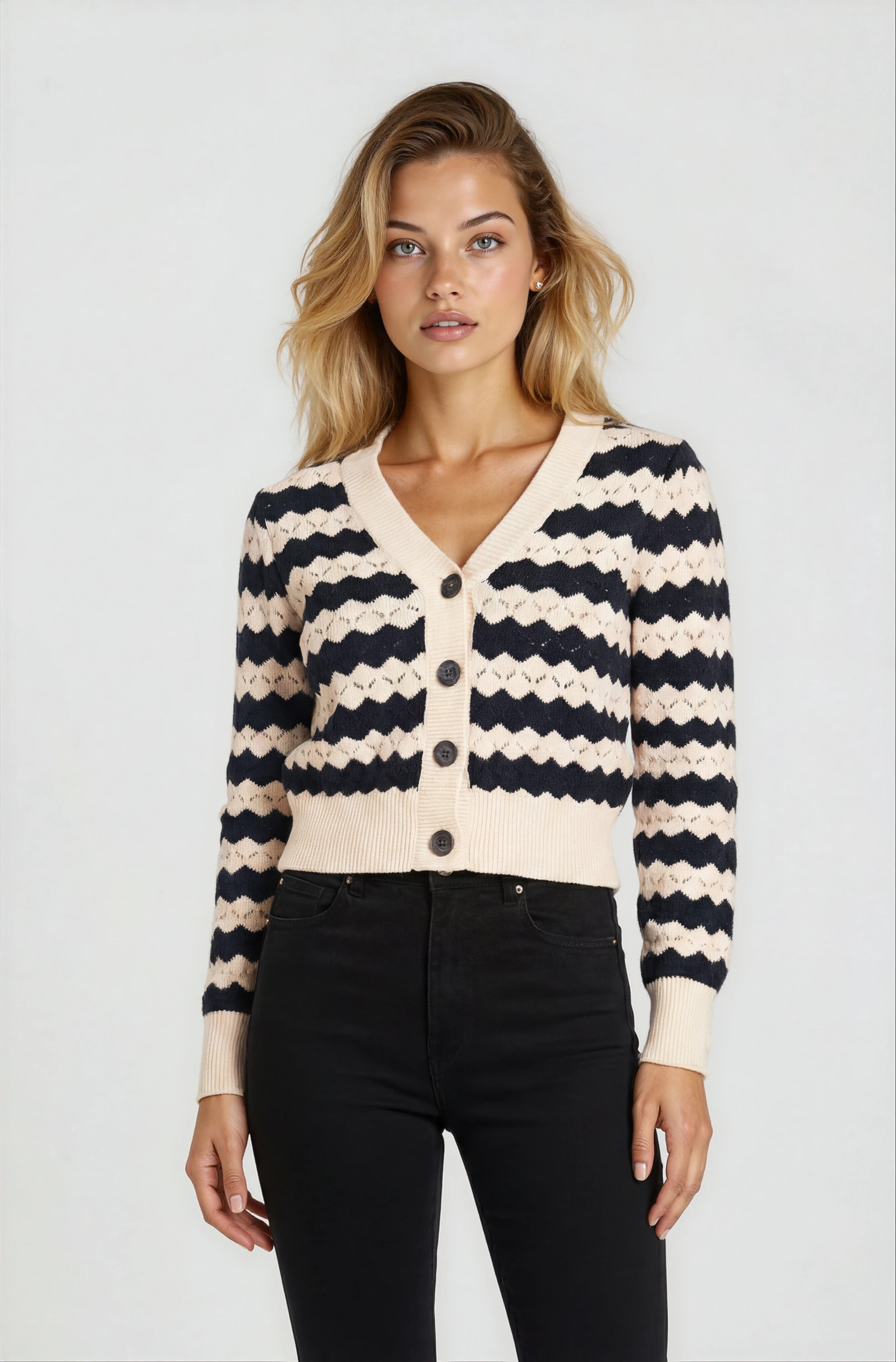 Woman wearing a black and white striped cardigan on a plain background