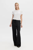Woman wearing a white t-shirt and black wide-leg pants on a white background