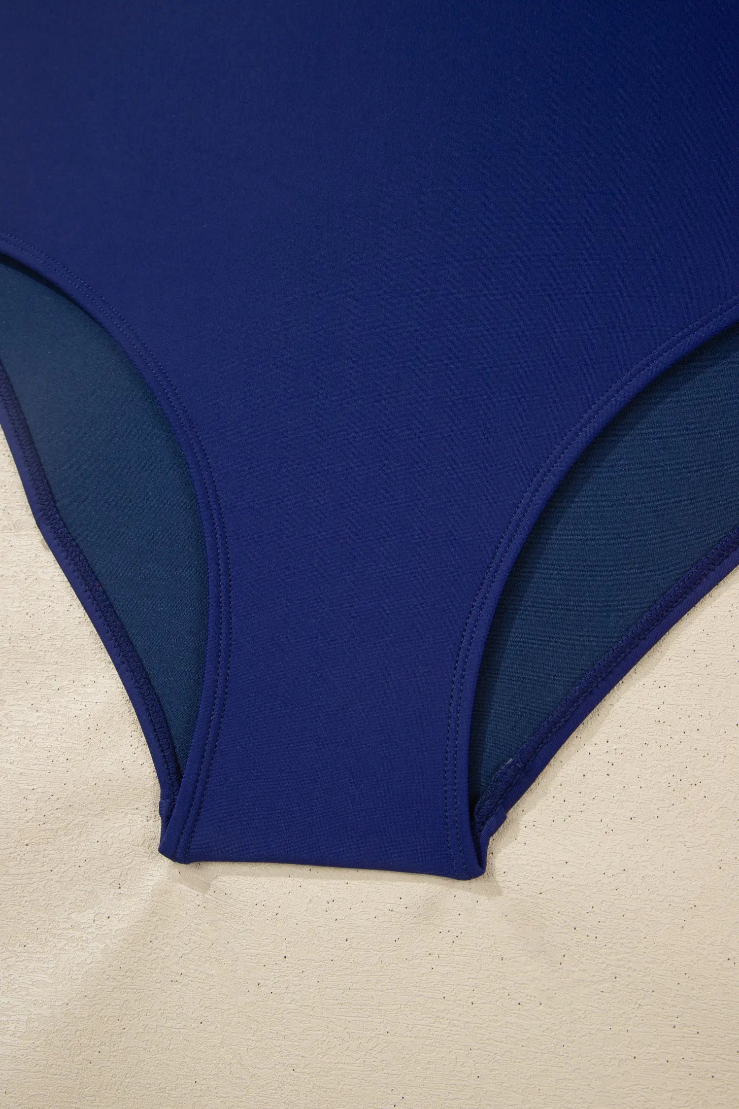 Blue swimsuit bottom on a beige surface