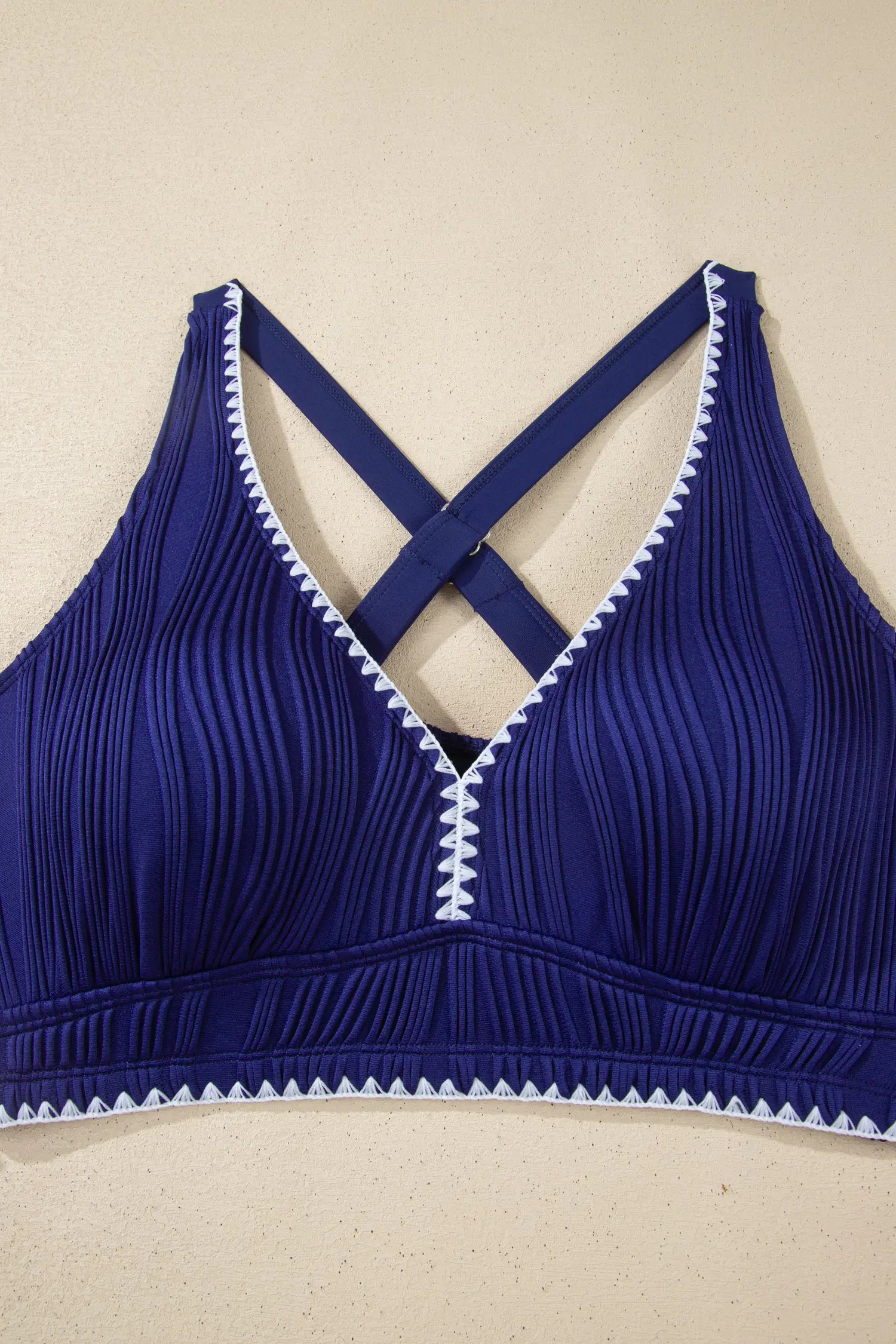 Blue bra with white trim on a beige background