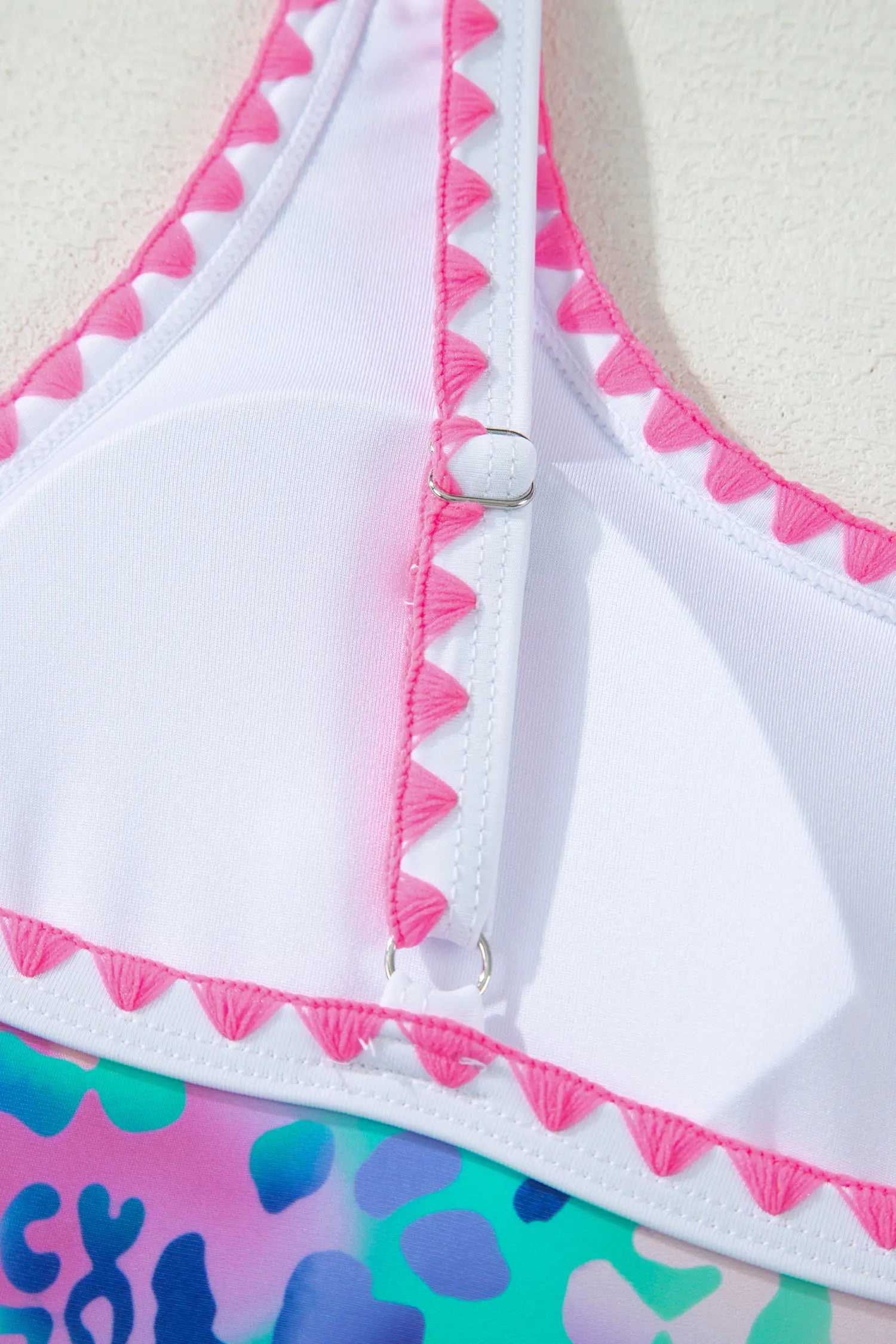 Close-up of a colorful bikini with pink trim on a white background