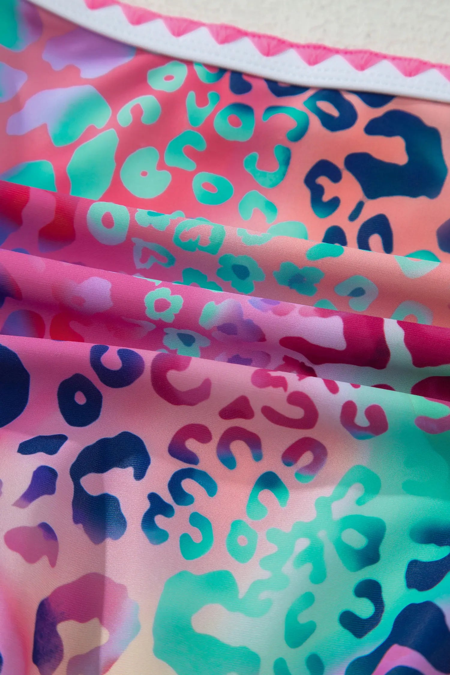Colorful fabric with leopard print pattern on a pink background