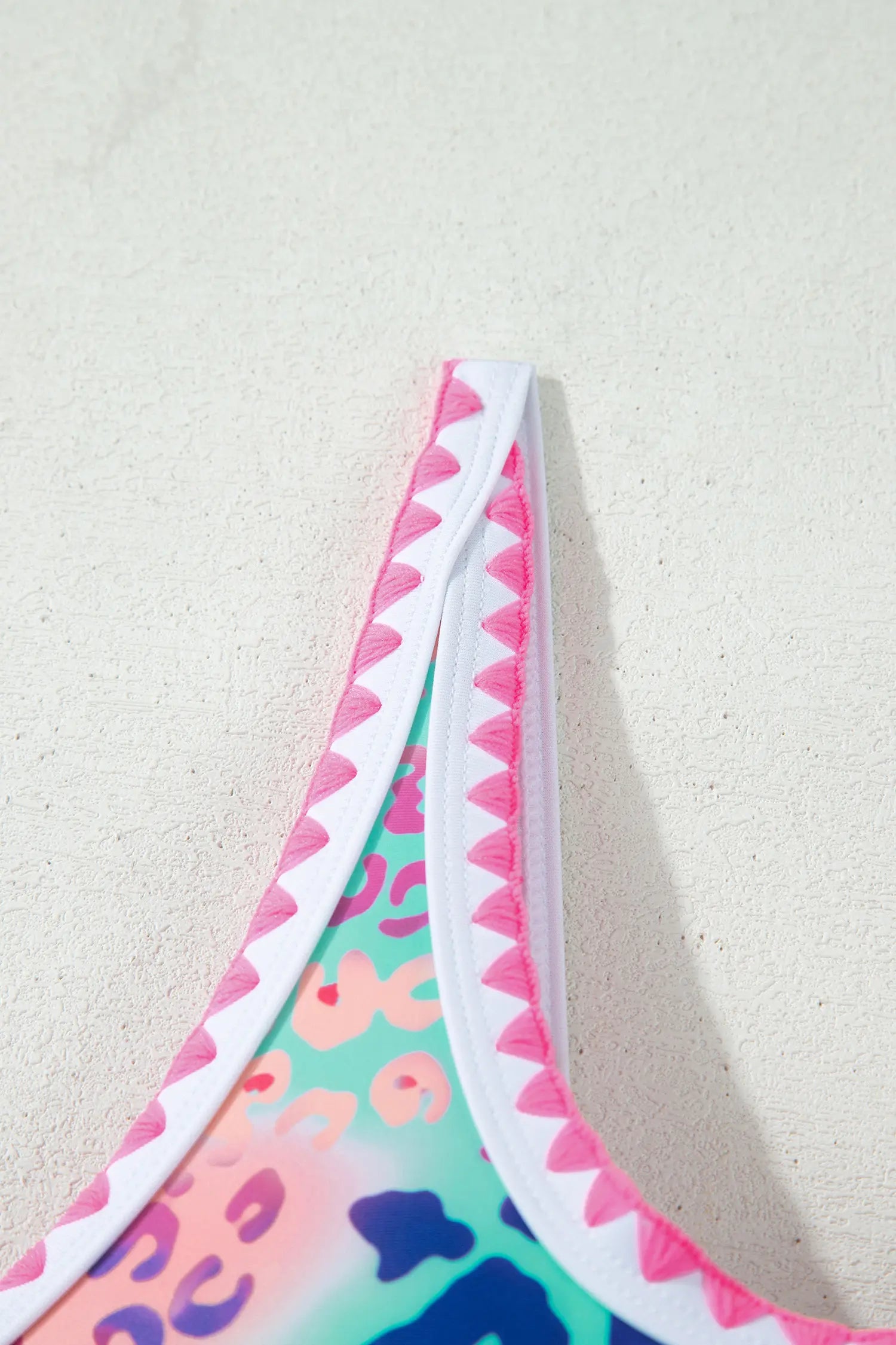 Multicolored bikini bottom with pink trim on a light background
