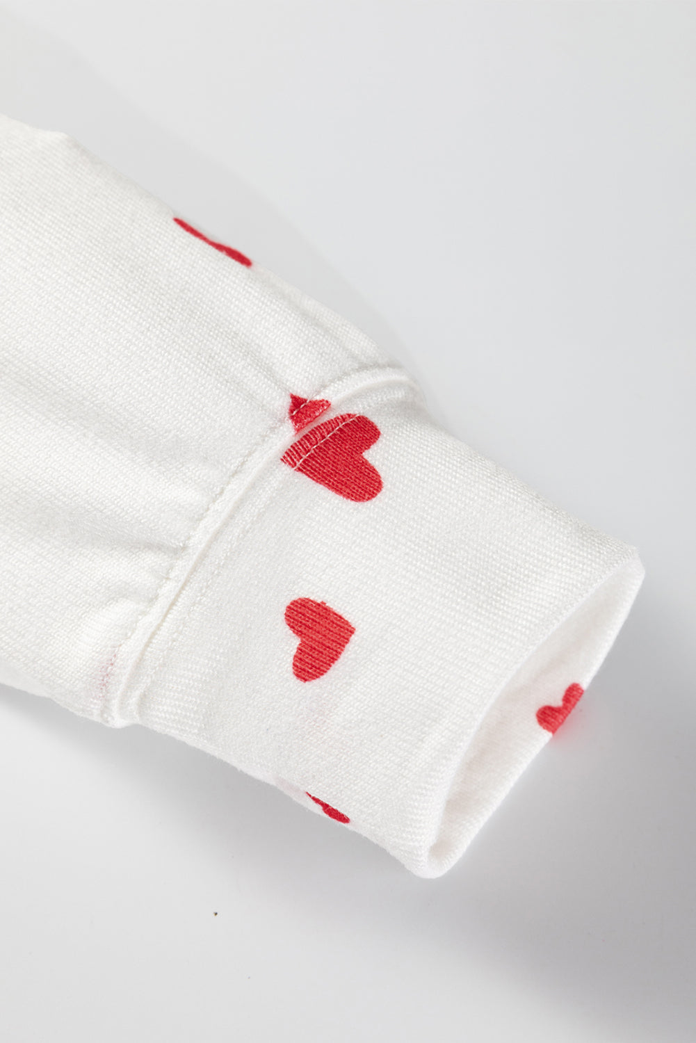 White fabric with red heart patterns on a white background