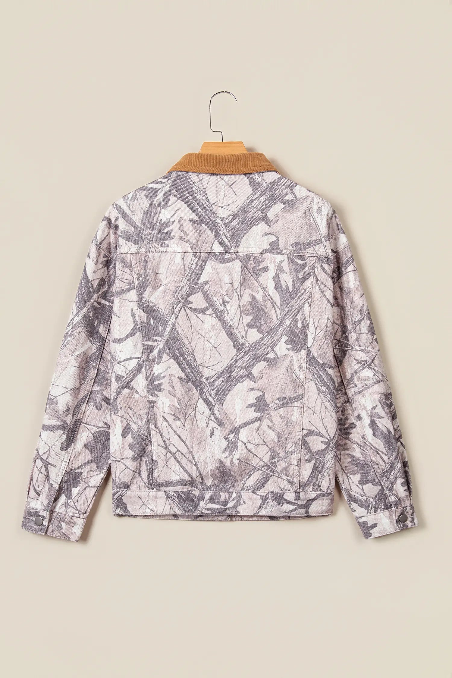 Children’s long-sleeve jacket with gray and beige tree-bark camouflage pattern on wooden hanger.