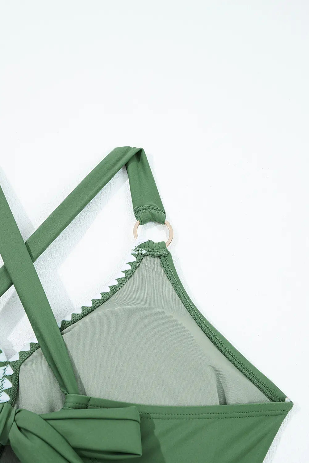Green bikini top with thin straps on a white background