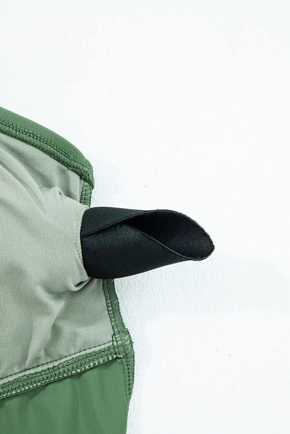 Close-up of a green and black fabric edge on a white background