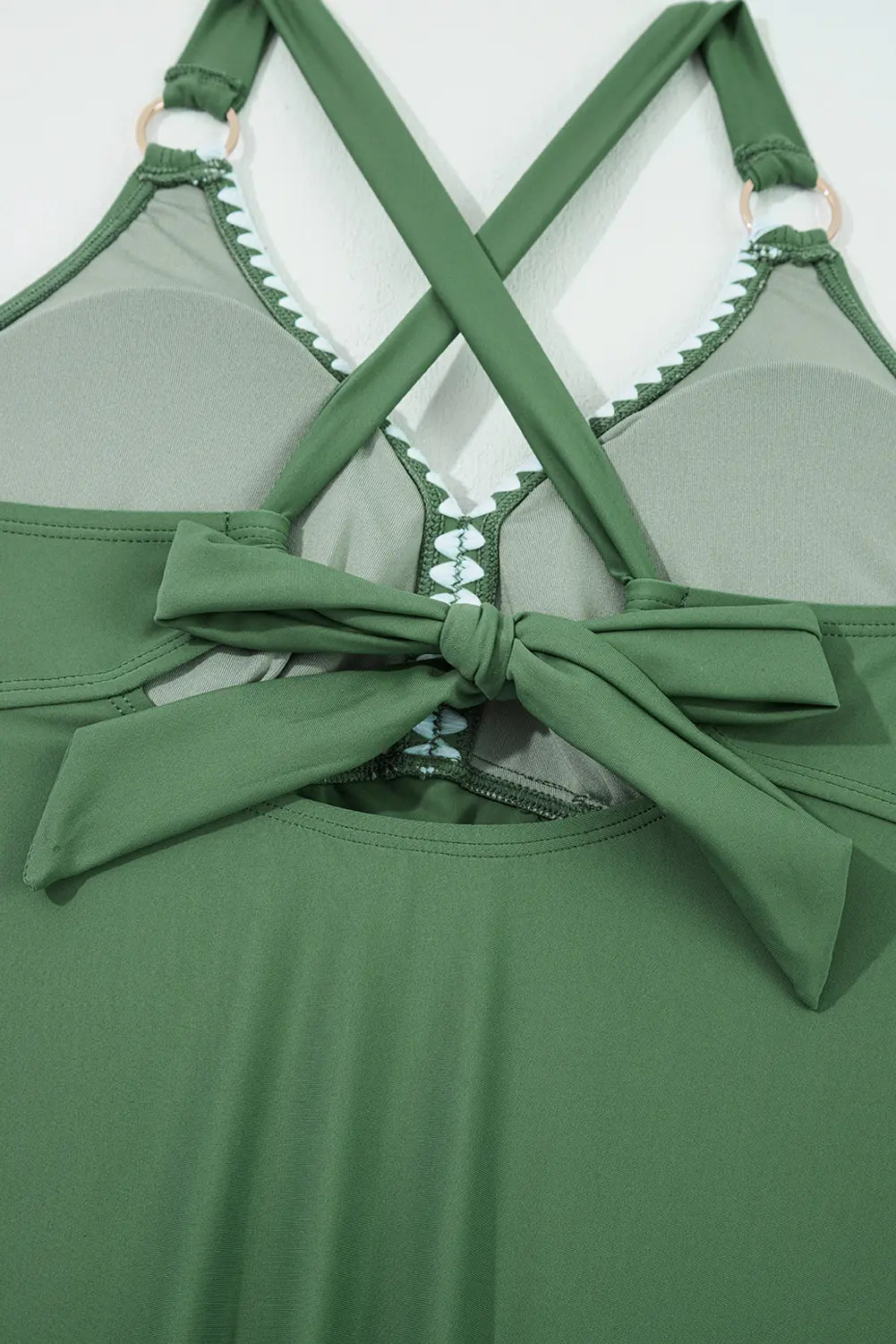 Green bikini top with a bow detail on a white background