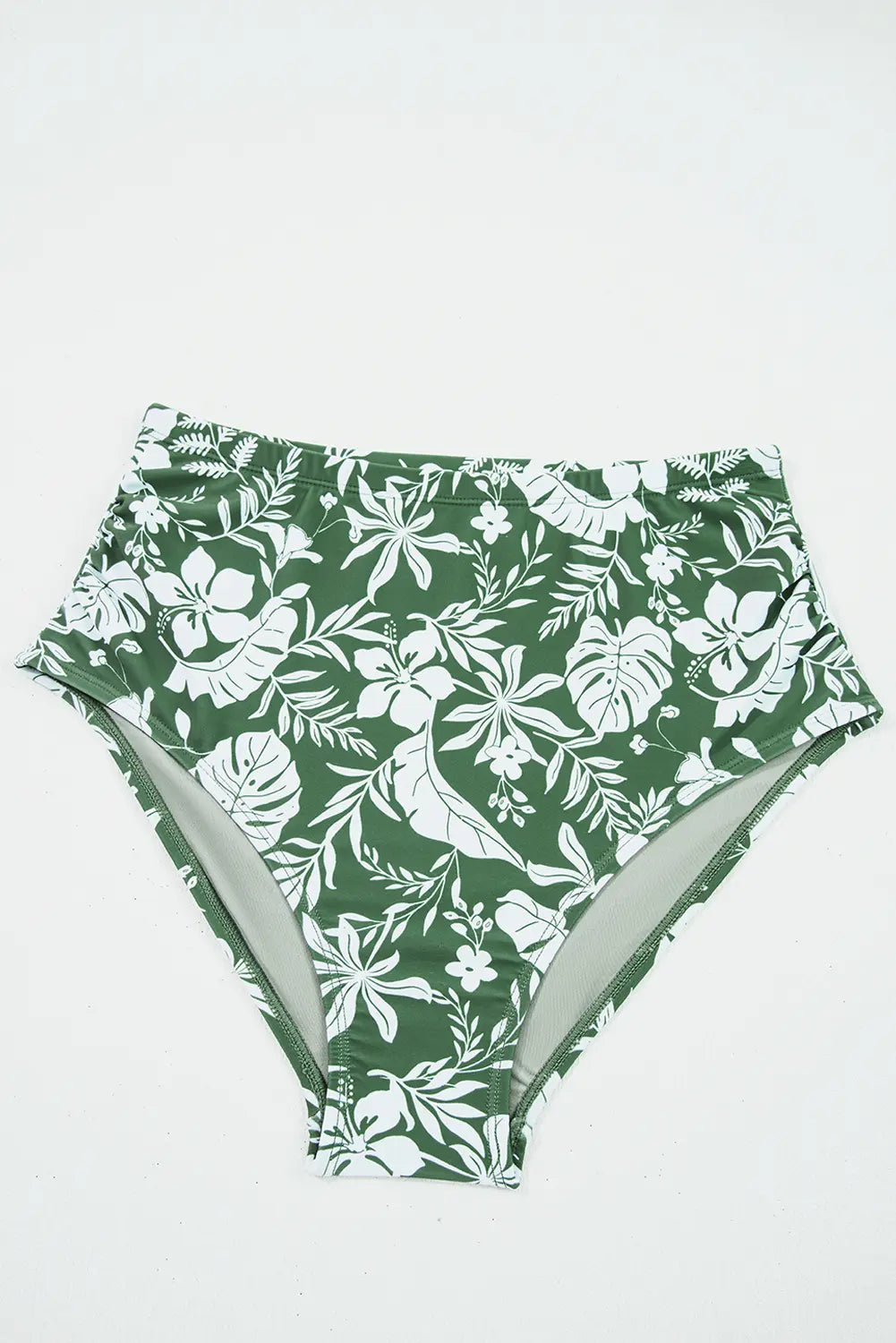 Green high-waisted bikini bottom with white floral pattern on a white background