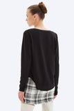 Woman wearing a black sweater and plaid skirt on a white background