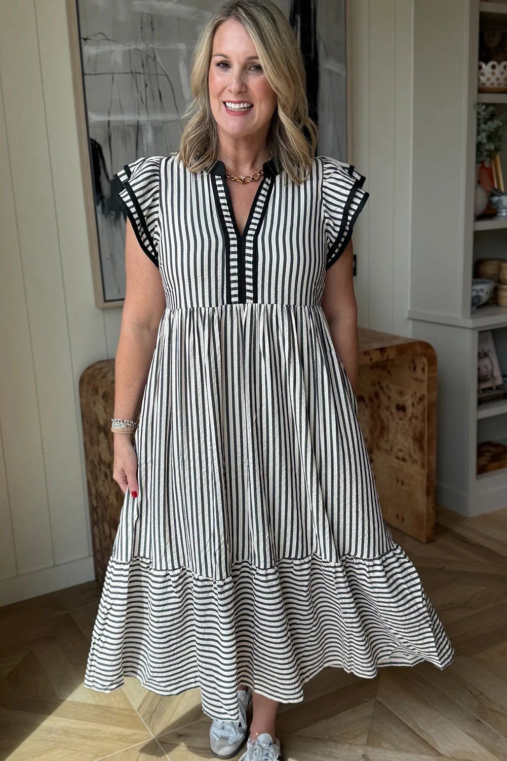 Woman wearing a black and white striped dress indoors.